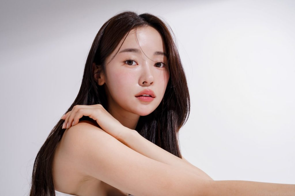 Portrait of a woman with glowing, refined skin and subtle makeup emphasizing smooth texture and facial symmetry