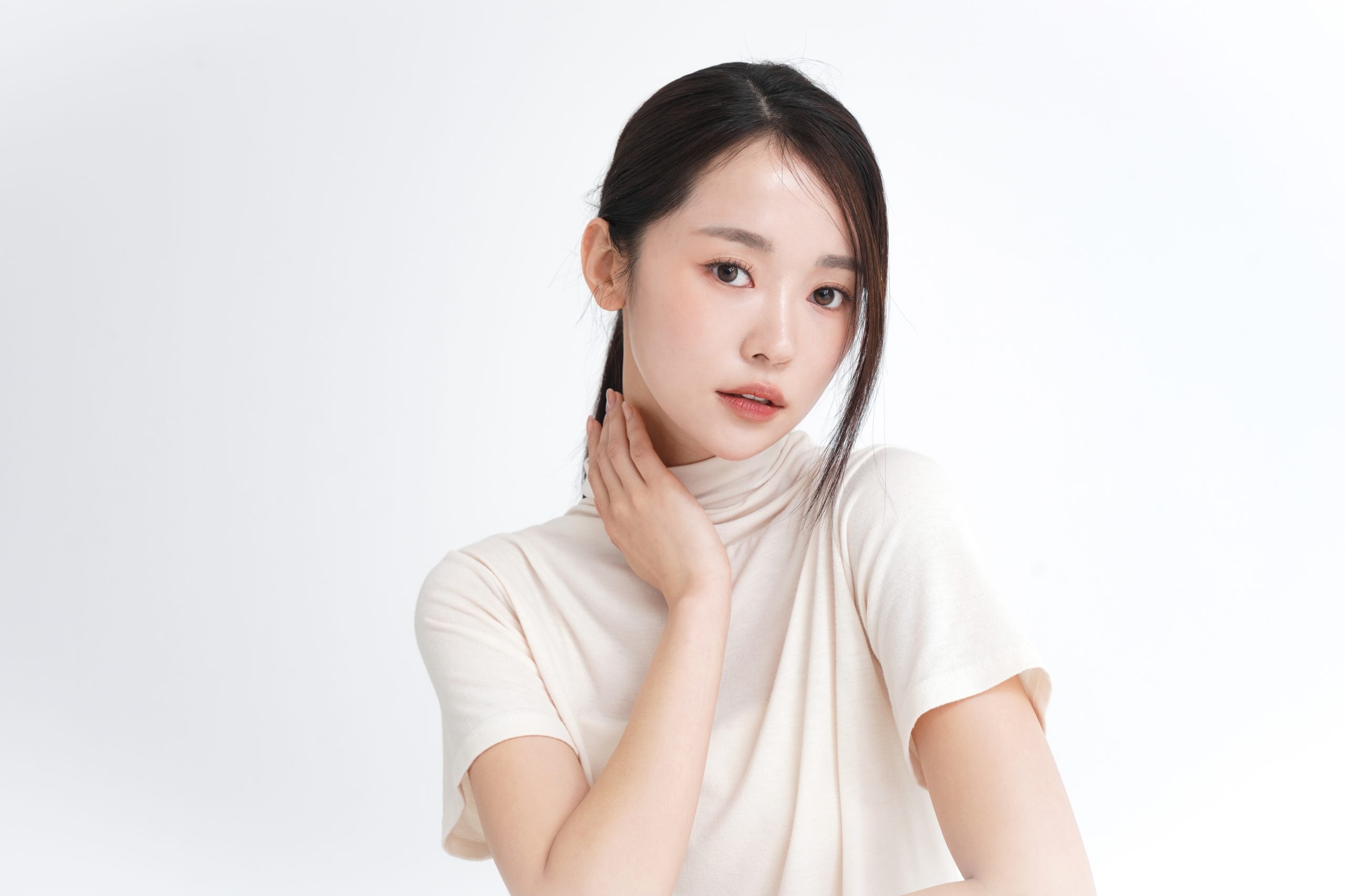 Asian woman with clear glowing skin gently touching her neck, ideal for Peel & Fill skin revitalization page