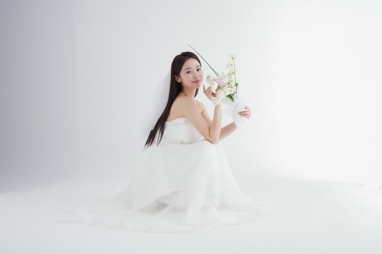 Bride in a white gown holding a delicate bouquet, radiant clear skin ready for a special occasion treatment