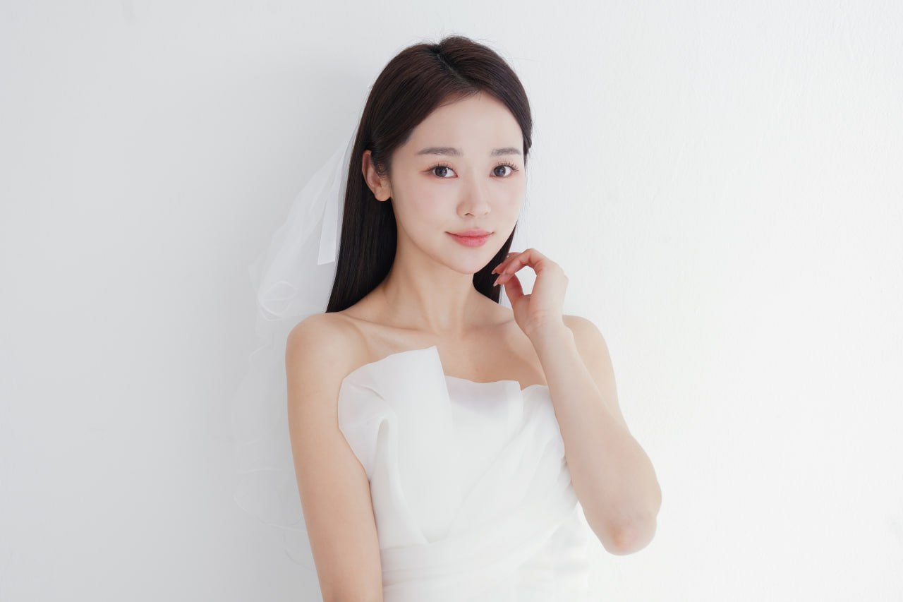 Woman in wedding dress with clear radiant skin smiling in a bright studio for special-occasion skincare
