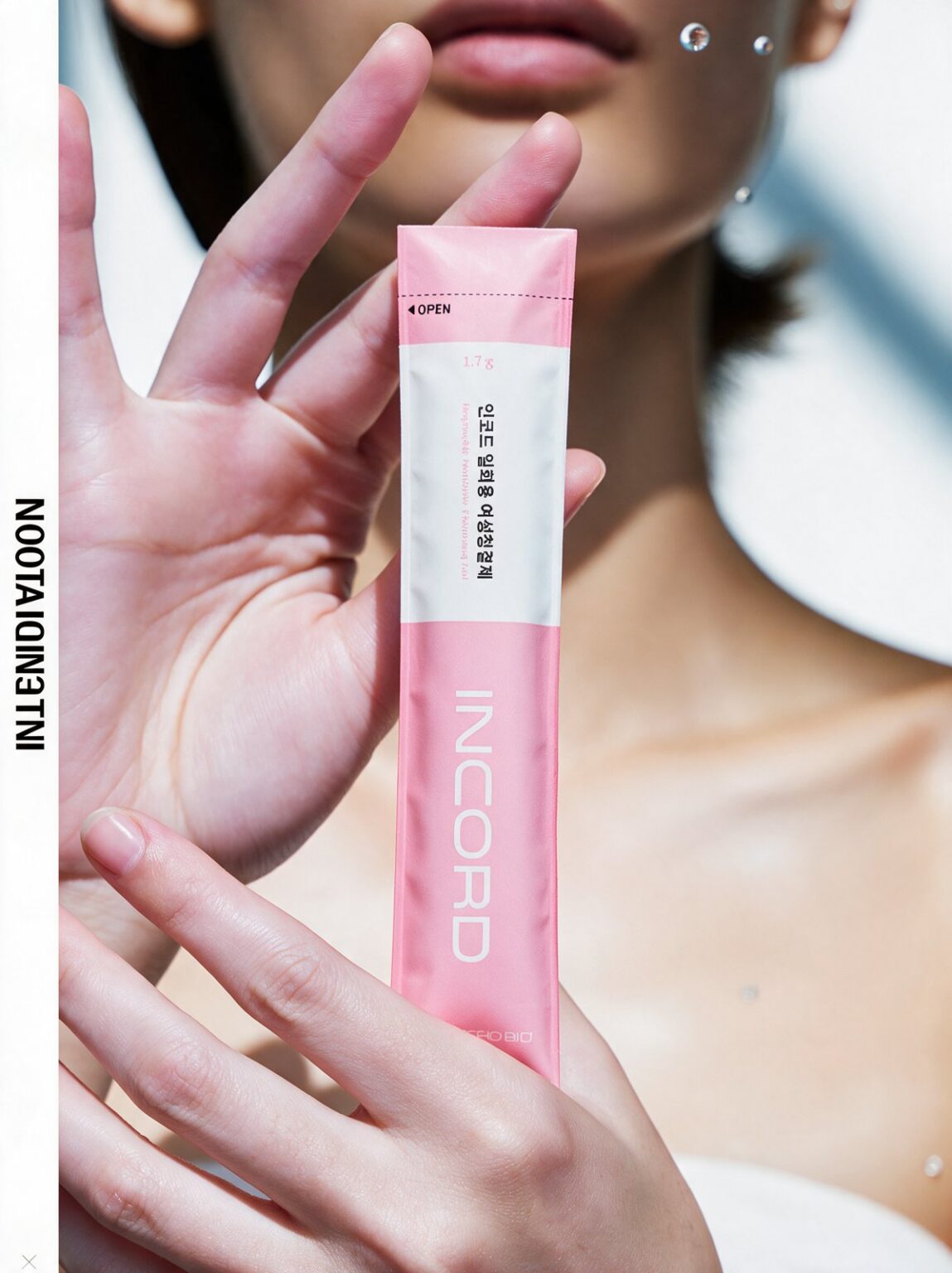 A woman holds a pink and white INCORD single-use stick pouch up close in front of her face in bright sunlight.